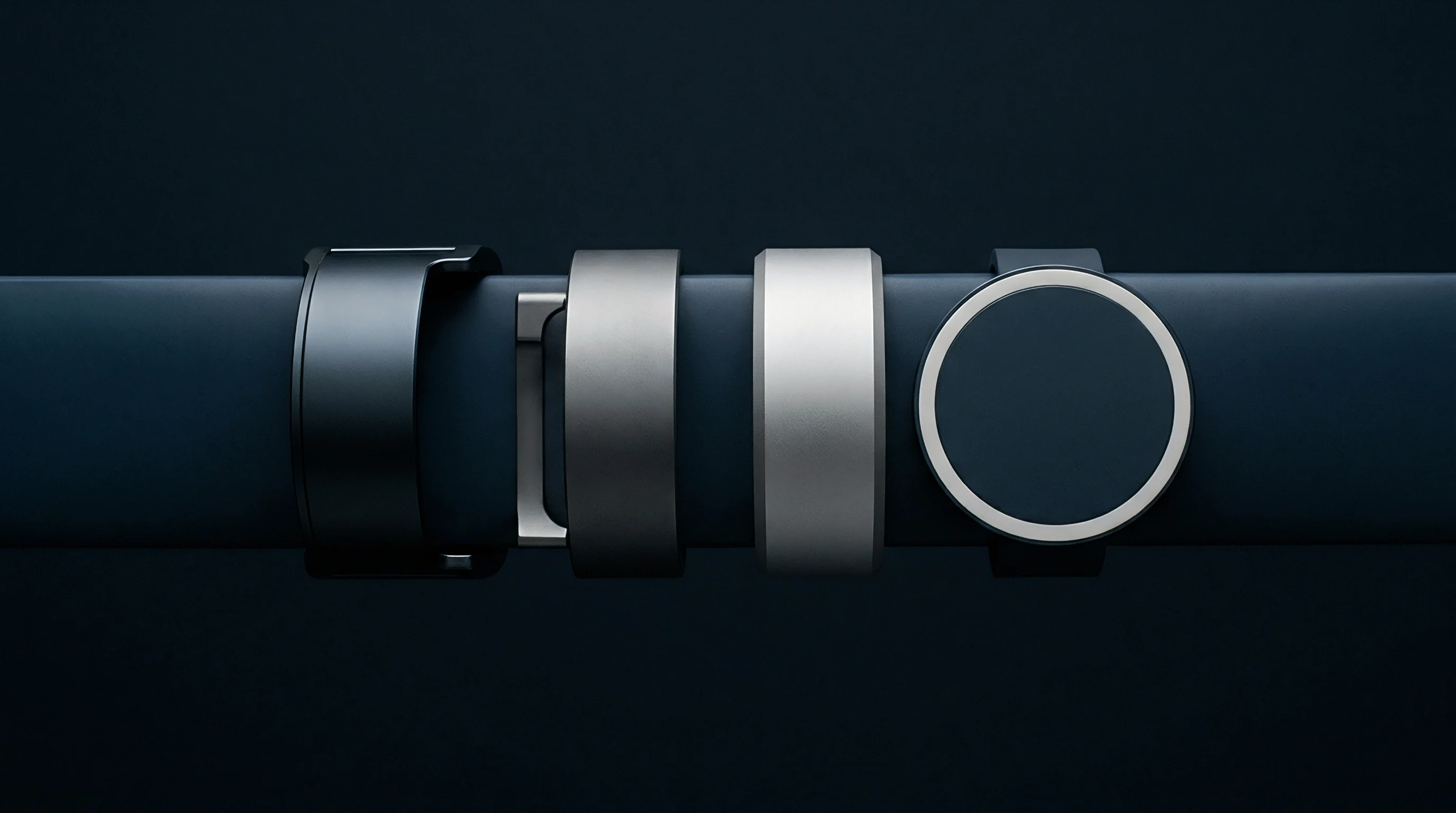 A digital render displays four distinct metallic wearable device prototypes arranged horizontally along a dark assembly line module surface.